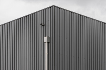 Modern building corner featuring gray corrugated metal siding texture