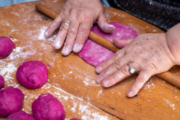 Woman hands making pastry. Colored bread dough making process.