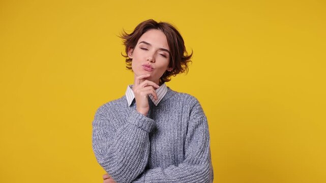 Smart proactive creative young woman wear grey sweater white shirt casual clothes look around think scratches at temple comes up with idea raised finger get plan isolated on plain yellow background
