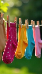 Vibrant colorful socks and underwear pegged to a rustic wooden clothespin clothesline outdoors, drying in the sun A charming summer scene of laundry day , fresh, natural fiber