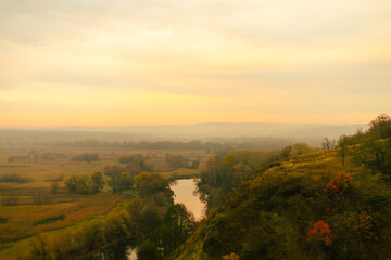 Obraz premium Scenic view of a winding river surrounded by autumn fields