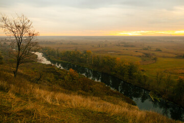 Fototapeta premium Scenic morning view of the valley and river under soft orange light