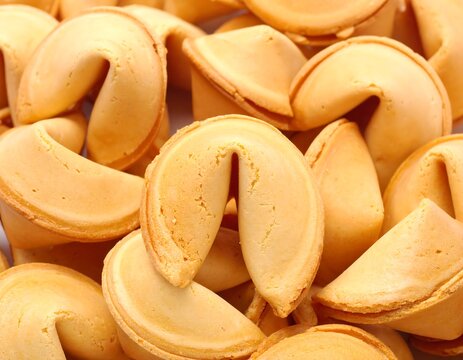 An overhead shot of a pile of golden-brown, crispy, and slightly curved baked treats. They're densely packed, showcasing varied shapes and textures