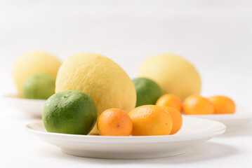 Fresh lemon, lime and kumquat on white background
