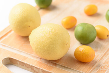 Fresh lemon, lime and kumquat on white background