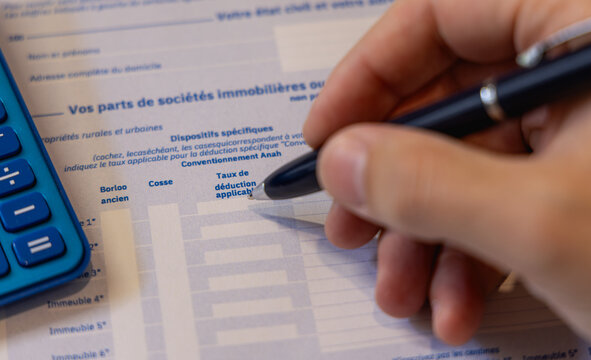 Une personne en train de remplir une case pour la d&eacute;claration des revenus des imp&ocirc;ts pour l&rsquo;ann&eacute;e 2026 en France.
