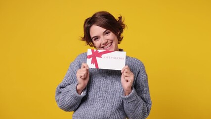 Young woman wear grey knitted sweater white shirt casual clothes pointing finger on gift certificate coupon voucher card for store show thumb up isolated on plain yellow background. Lifestyle concept - Powered by Adobe