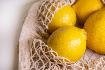 Fresh Lemons in Mesh Bag – Modern Lifestyle Concept on White Minimal Background