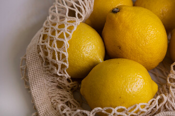 Fresh Lemons in Mesh Bag – Modern Lifestyle Concept on White Minimal Background