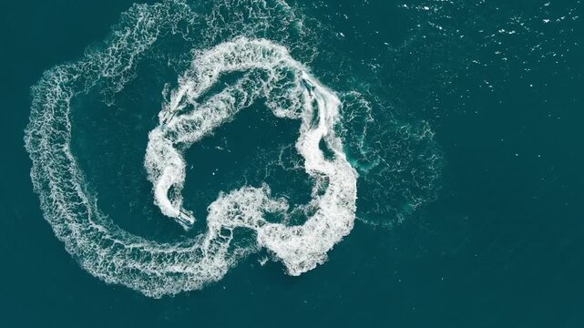 1080 Drone shot of jetskis riding in blue waters from the sky