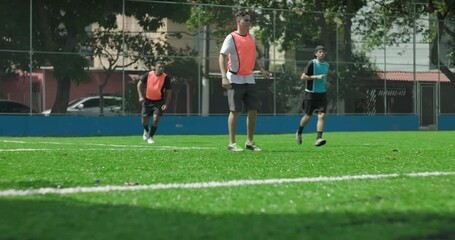 Friends playing friendly soccer game near goal on small urban field, teammates competing for ball during casual match, concept of community, teamwork, and recreation - Powered by Adobe