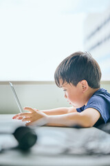 ノートパソコンでオンライン学習をする小学生の男の子