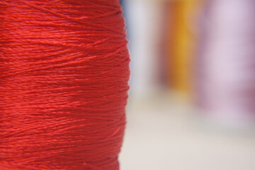 A close-up captures the textured beauty of a spool of vibrant red thread, hinting at the artistry of textile creation and craftsmanship. 