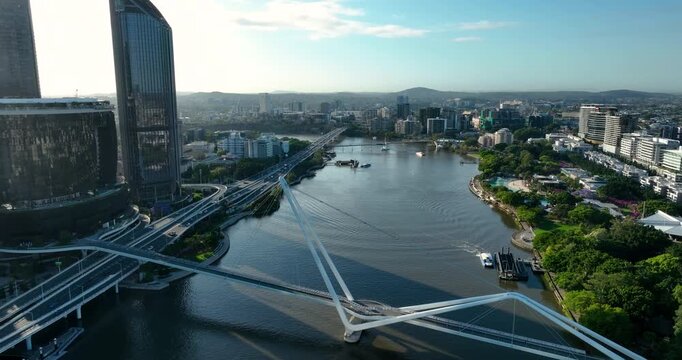 4K Aerial Push in tracking shot of west side of Brisbane City CBD also known as South Bank Precinct with new buildings and a new pedestrian bridge called Neville Bonner Bridge, Brisbane, QLD,Australia