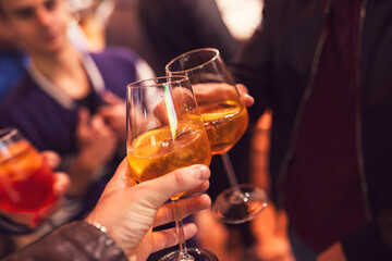 People toasting aperol spritz cocktails during celebration event
