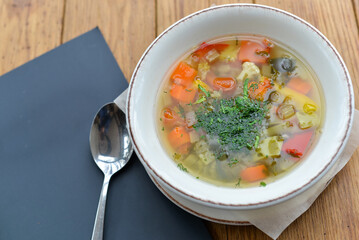 vegetable soup in a beautiful plate on a wooden table
