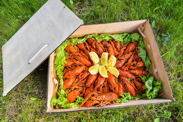 a box full of crayfish boiled with lemon and herbs on grass