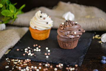 two baked muffins on a black slate