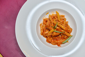 pasta with tomato sauce in a white plate on a background