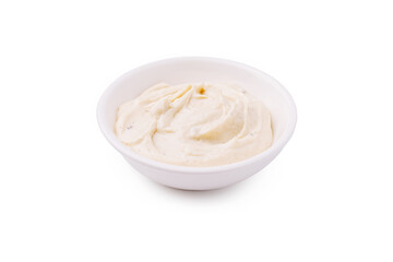 Creamy dip served in a white bowl on a plain background