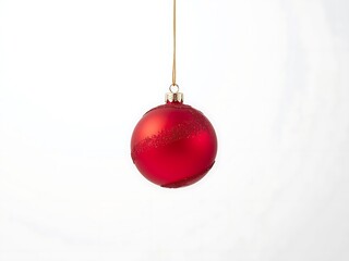 A beautiful red Christmas ornament hanging against a white background
