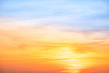 Sunset or sunrise sky with a vibrant gradient of orange, gold, and soft blue. Clear atmosphere with wispy clouds. Peaceful, natural light background. hope, freedom, new day and inspirational Concepts