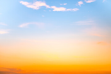 Obraz premium Sunset or sunrise sky with a vibrant gradient of orange, gold, and soft blue. Clear atmosphere with wispy clouds. Peaceful, natural light background. hope, freedom, new day and inspirational Concepts