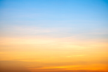 Sunset or sunrise sky with a vibrant gradient of orange, gold, and soft blue. Clear atmosphere with wispy clouds. Peaceful, natural light background. hope, freedom, new day and inspirational Concepts