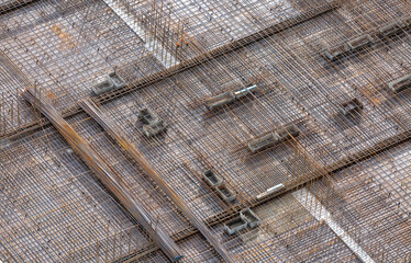 Fototapeta premium Reinforcing mesh laid on a base for pouring concrete to create a monolithic floor between the floors of a high-rise building