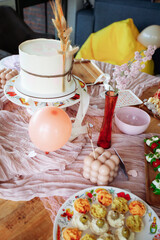 Baby shower setup with pastel balloons, cake and wrapped gifts on a cozy table, soft natural light and copy space&mdash;perfect for invitations and social posts.