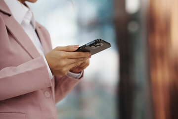 Close-up of a businesswoman using a smartphone, representing communication, technology, work, and modern lifestyle.