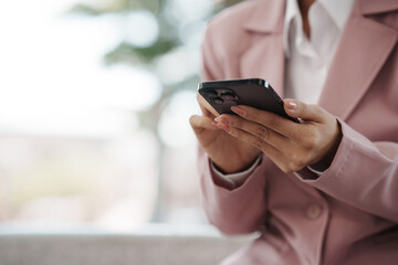 Close-up of a businesswoman using a smartphone, representing communication, technology, work, and modern lifestyle.