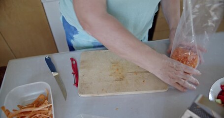 Woman's hands meticulously peel fresh carrots in a warm kitchen, preparing healthy ingredients for a homemade meal. Capturing the essence of home cooking and fresh produce for nutritious living.
