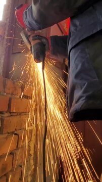 metal cutting: worker removing support from brick wall
