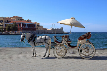 Traditional horse-drawn carriages on the Old Venetian Port of Chania, Crete, Greece
