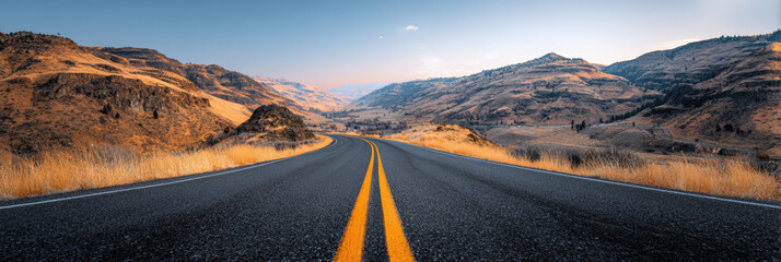 Scenic travel journey on an empty asphalt road and highway through mountain landscape. peaceful drive at sunset evokes feeling of adventure and absolute freedom