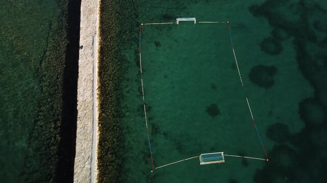 water polo field by the sea, by the concrete jetty, sunny day, summer, calm sea, view from a drone