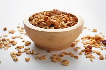 Tasty granola with nuts and raisins on white table, closeup