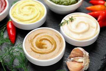 Different sauces and herbs on table, closeup
