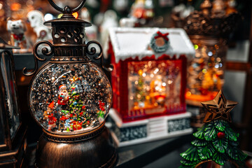 A Christmas crystal ball with snow and Santa Claus inside, New Year's gifts and souvenirs at a holiday fair