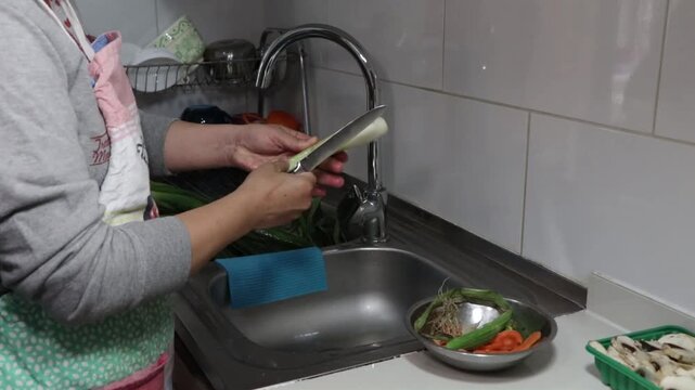 pelando y lavando un ceboll&iacute;n en la cocina