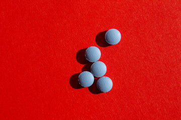 Blue pills on red background