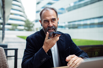 Mature businessman using smartphone outdoors