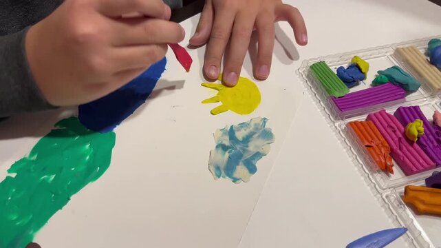 Child engaged in creative art activity, using colorful modeling clay and paintbrush, showcasing vibrant textures and playful expression, camera follows hand movements