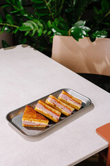 Delicious layered sandwich served on a tray in a modern cafe setting