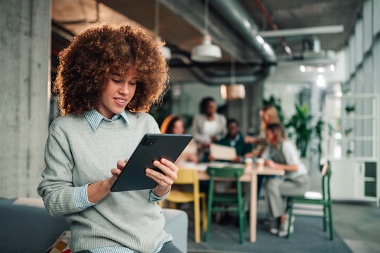 Professional woman using tablet working in modern office - Powered by Adobe