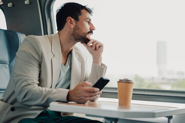 Man commuting by train, looking out window