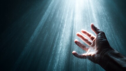 Hand reaching towards divine light and rays of sunlight hope and spiritual guidance