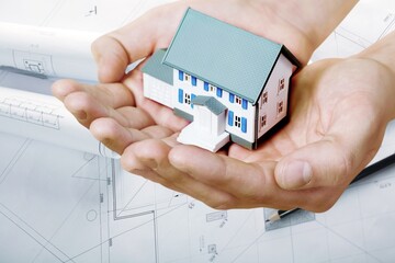 A concept of building application, house model with construction plans