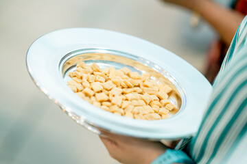 Sosteniendo entre sus manos el pan de la cena del señor que se repartirá en la iglesia 